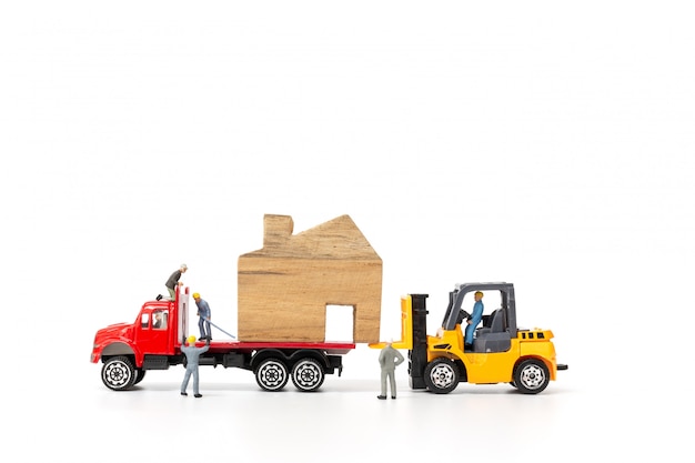 Personnes miniatures: équipe de travailleurs déménagement maison, immobilier et concept d'entreprise immobilière