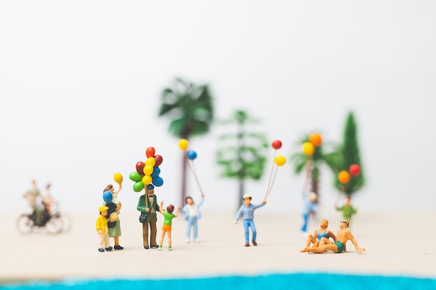 Personnes miniatures: famille heureuse profiter des vacances d&#39;été sur la plage