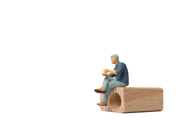 Personnes miniatures Homme d'affaires assis sur une chaise en bois isolé sur fond blanc et espace pour le texte