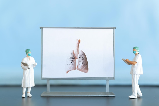 Personnes miniatures Un médecin examine la pneumonie sur la photo une maladie respiratoire