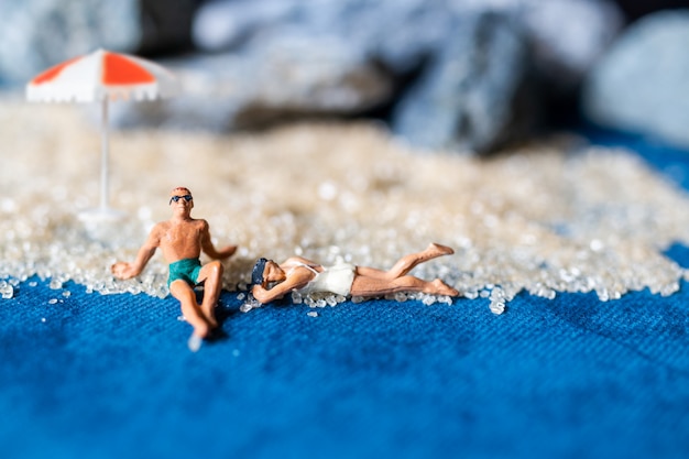 Personnes miniatures portant un maillot de bain relaxant sur la plage