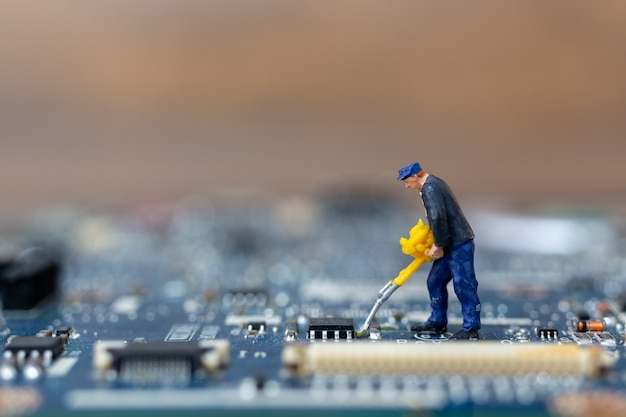 Personnes miniatures travaillant sur la carte CPU