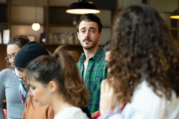 Des personnes multiraciales réunies en équipe se concentrent sélectivement sur un gars en chemise verte