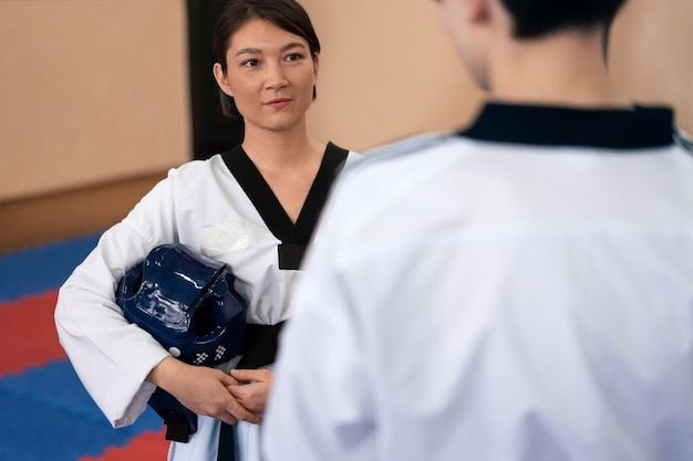 Photo personnes pratiquant le taekwondo dans un gymnase