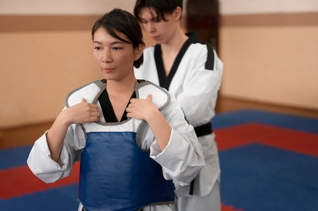 Photo personnes pratiquant le taekwondo dans un gymnase