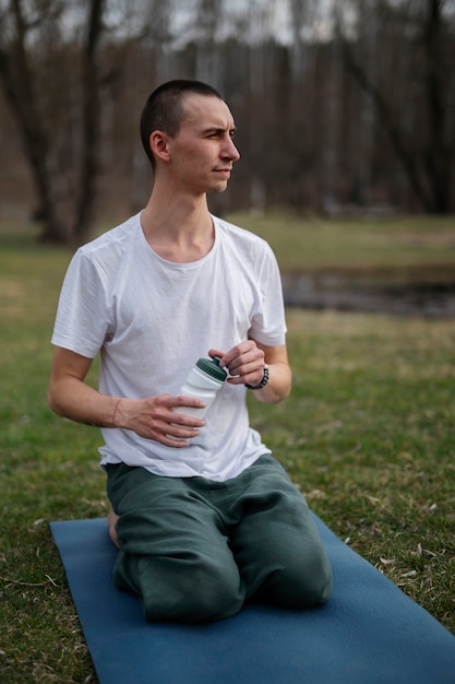 Photo personnes pratiquant le yoga à l'extérieur