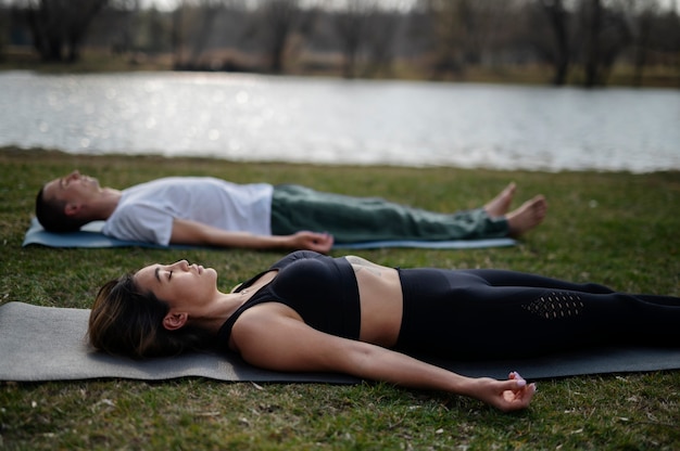 Photo personnes pratiquant le yoga à l'extérieur