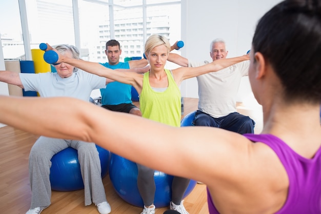 Personnes qui travaillent avec des haltères dans un club de fitness