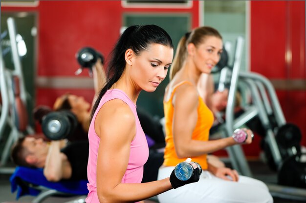 Personnes en salle de sport avec des poids