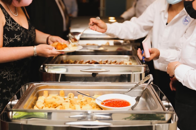 Personnes servant de la nourriture à un buffet