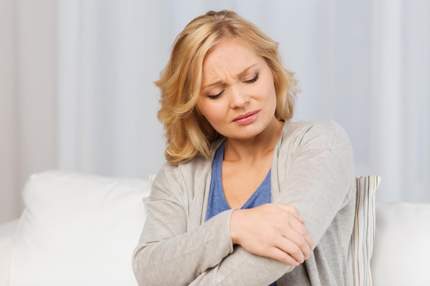 personnes, soins de santé et concept de problème - femme malheureuse souffrant de douleur à la main à la maison