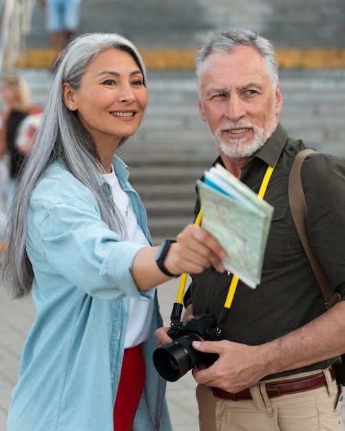 Personnes souriantes à plan moyen avec carte