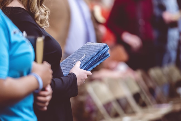 Personnes tenant des livres bibliques et priant pendant une congrégation