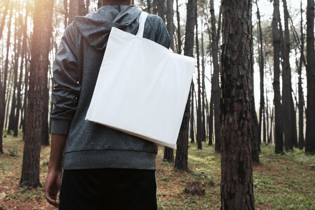 Photo personnes tenant un sac en coton pour maquette vierge au fond de la nature