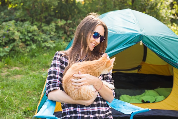 Personnes, tourisme d'été et concept nature - jeune femme avec chat près de la tente.