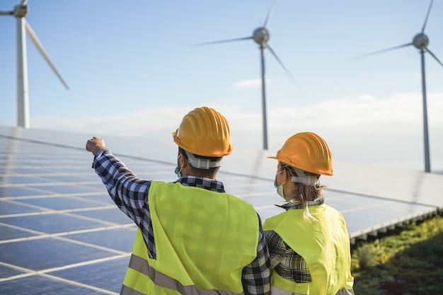 Les Personnes Travaillant Pour La Ferme D'énergie Alternative - Processus De Générateurs D'énergie éolienne Et Panneaux Solaires