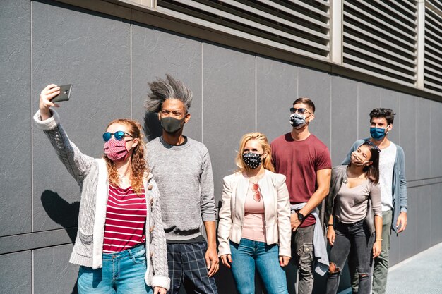 Photo personnes urbaines mileniales prenant un selfie avec un masque facial sur la quatrième vague de covid