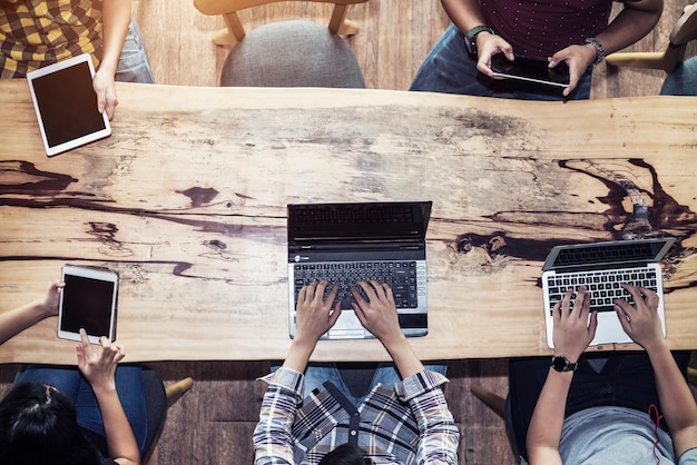 Personnes utilisant un gadget pour travailler sur une table