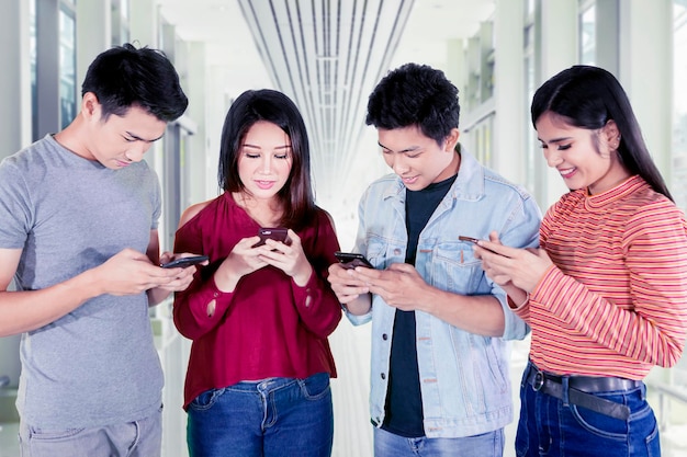 Personnes utilisant un téléphone portable dans le couloir