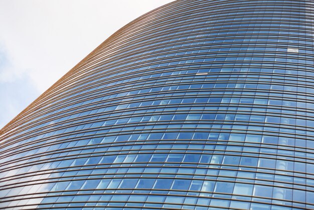 Perspective et angle angle de vue à fond texturé de gratte-ciel de bâtiment en verre moderne sur ciel bleu nuageux