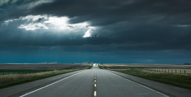 Perspective décroissante de la route contre un ciel nuageux