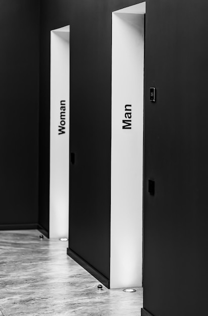 Perspective d'un long couloir dans un immeuble de bureaux Portes de toilettes dans le couloir Portes dans un bureau avec des panneaux de toilette Entrée dans les toilettes d'une usine