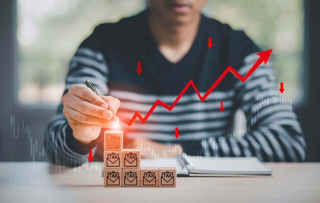 Pertes commerciales sur la taxe sur le concept de cube en bois, les cubes en bois tactiles à l'aide d'un stylo et les flèches rouges tombent au sol, indiquant la récession économique qui se produira en 2022