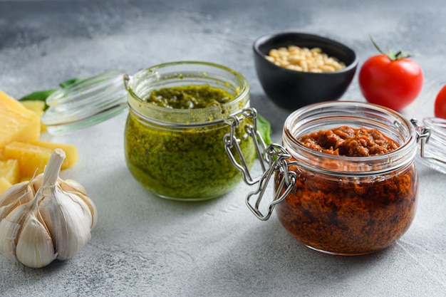 Pesto vert et rouge fait maison et autres ingrédients de cuisine