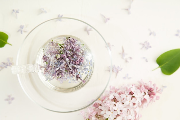 Pétales de lilas dans une coupe en verre blanc