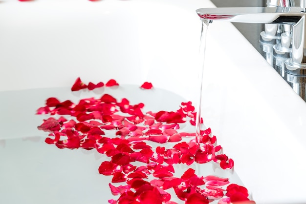 Pétales de roses rouges dans la baignoire dans la chambre de costume de lune de miel.