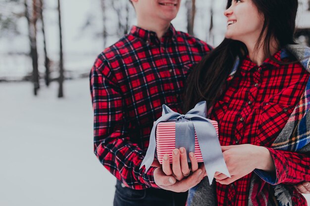 Petit ami donnant une boîte-cadeau présente avec un ruban en raison de la Saint-Valentin