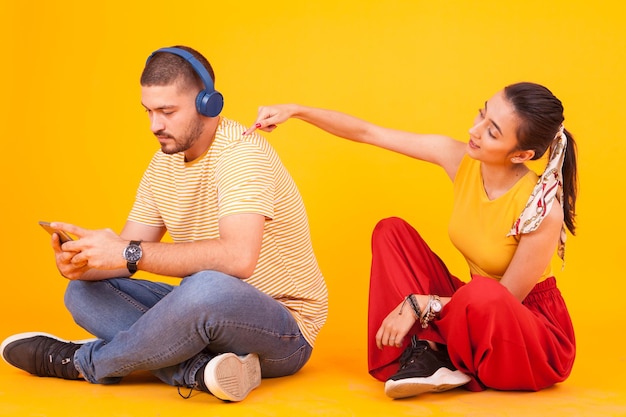 Petit ami utilisant son smartphone en ignorant sa belle petite amie. Jeune couple.