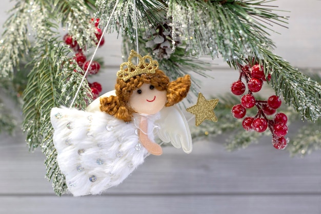 Petit ange mignon avec une décoration de baguette magique sur un sapin de Noël se bouchent