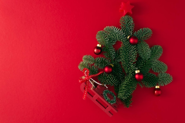 petit arbre de Noël assemblé à partir de vraies branches avec un décor sur un espace de copie de fond rouge