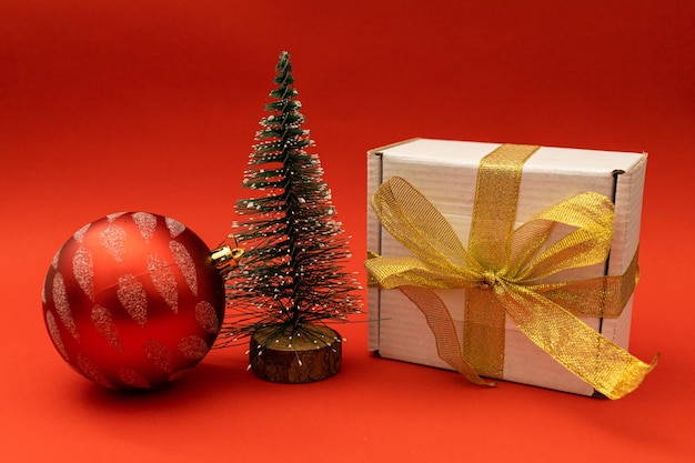 Un petit arbre de Noël sur un fond de vacances rouge