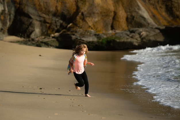 Petit athlète en formation runner exerçant le jogging pour les enfants enfant courir au bord de la mer les enfants s'exécutant sur b