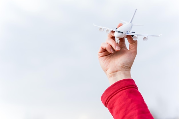 Petit avion jouet volant dans le ciel dans la main de l'homme Symbole de la fin de la quarantaine et de l'auto-isolement en raison de la pandémie de coronavirus covid19 Ouverture des frontières entre les pays et début des vols