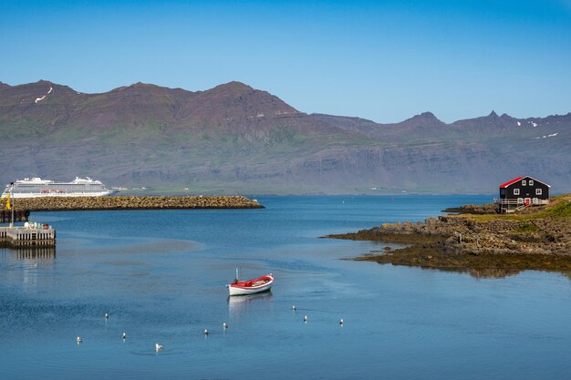 Photo petit bateau au mouillage de la côte de djupivogur en islande