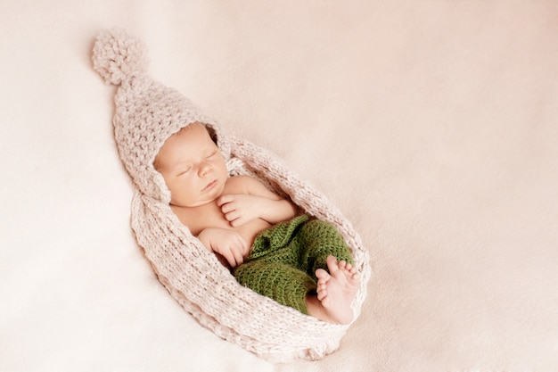 Petit bébé caché dans un bonnet de laine