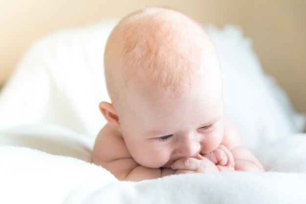 Petit bébé couché sur la couverture blanche