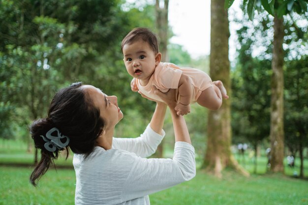 Le petit bébé est heureux quand sa mère le soulève