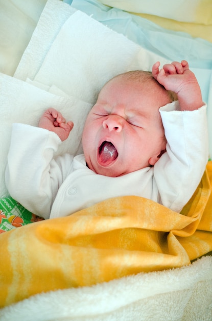 Un petit bébé est tendu le matin au lit