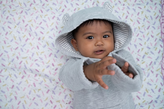 Photo petit bébé garçon couché sur une couverture douce