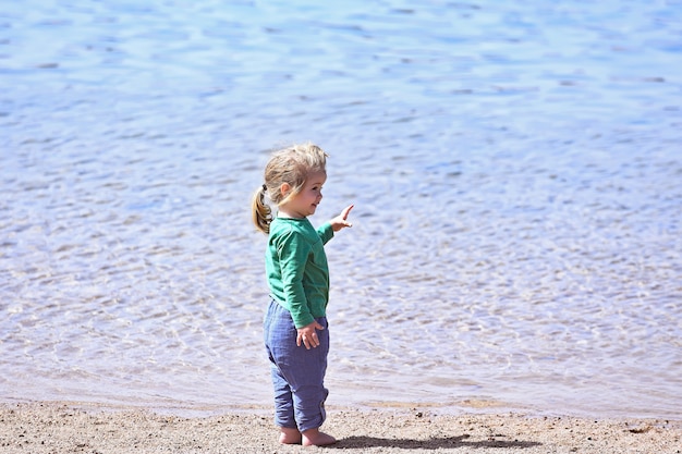 Photo petit bébé garçon à la plage de la mer ou de l'océan enfants vacances d'été en plein air enfance et bonheur