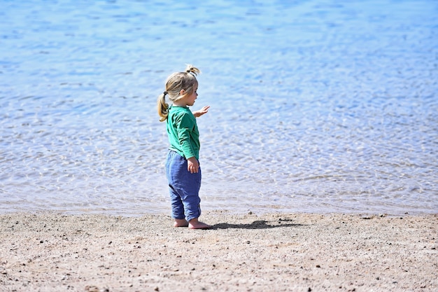 Petit bébé garçon à la plage de la mer ou de l'océan vacances d'été en plein air enfance et bonheur