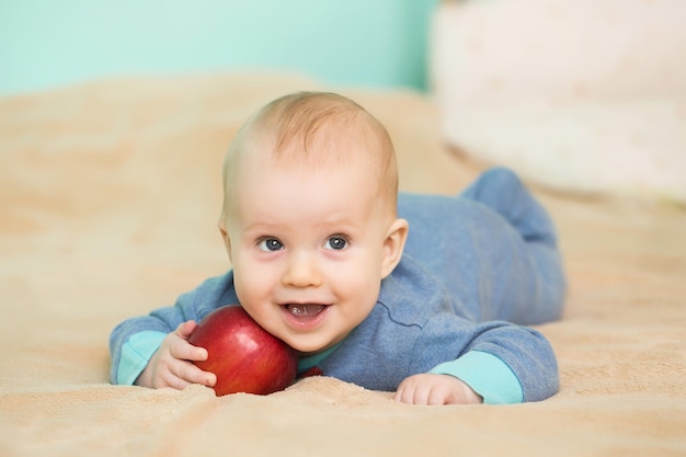 Petit bébé heureux avec pomme rouge