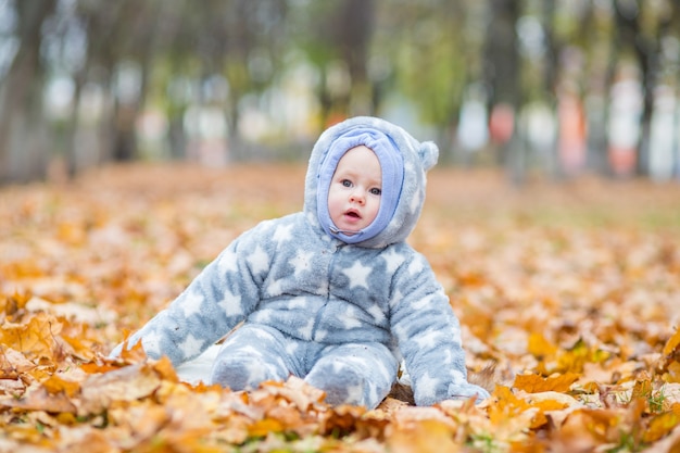 Petit bébé joue dans le parc d'automne Petite fille avec chêne et feuille d'érable Feuillage d'automne