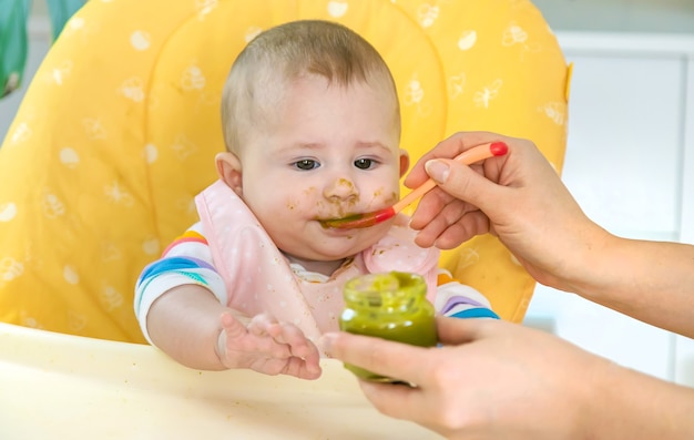 Le petit bébé mange de la purée de brocoli. Mise au point sélective. Gens.