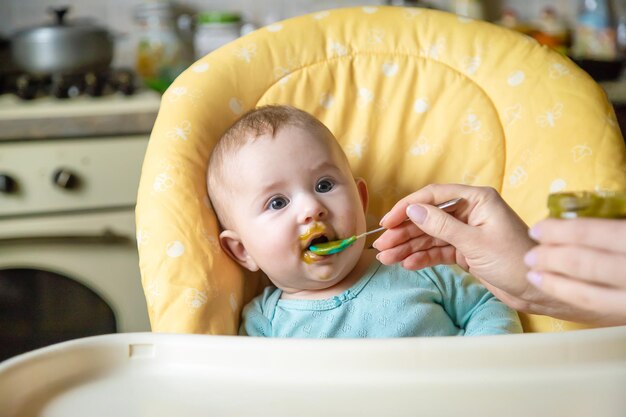 Petit bébé mange de la purée de légumes au brocoli Mise au point sélective