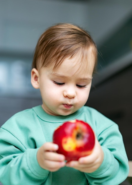 Petit bébé mangeant une pomme Concept de soins de santé et de nutrition infantile saine